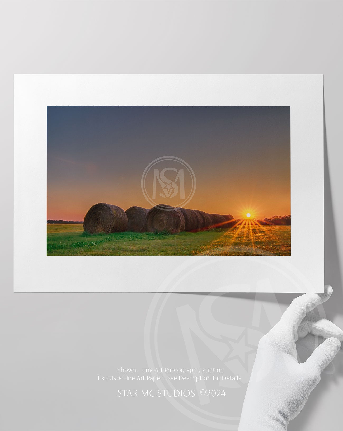 Golden hay bundles resting in a green pasture beneath a cloudy sky, captured in limited edition Southern fine art photography on museum-quality paper.