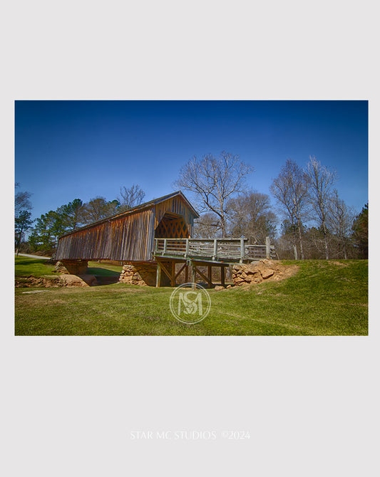 Historic Auchumpkee Creek covered bridge spanning a serene wooded creek, captured in limited edition Southern fine art photography for art collectors.